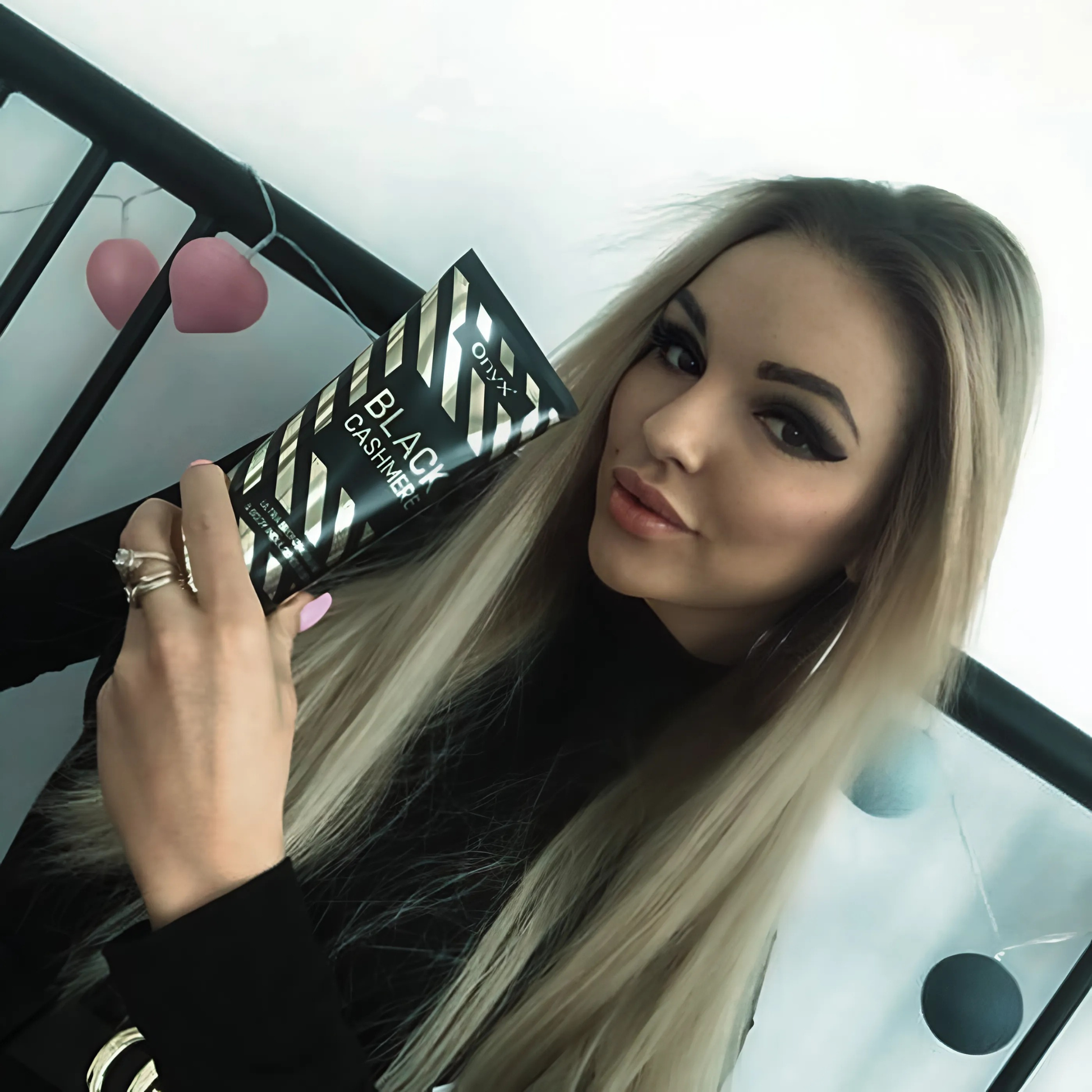 Kobieta prezentująca Onyx Black Cashmere – luksusowy bronzer do opalania o intensywnym działaniu, który nadaje skórze ciemny kolor.