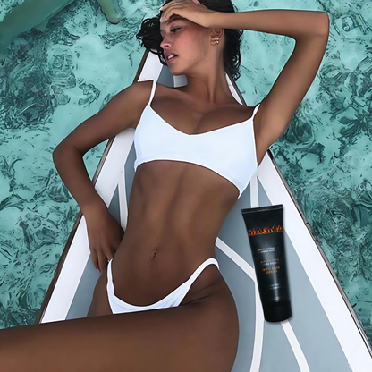 Kobieta w białym bikini opala się przy wodzie z bronzerem Onyx Magma. Efekt tingle zapewnia wyjątkowo głęboki ton skóry.