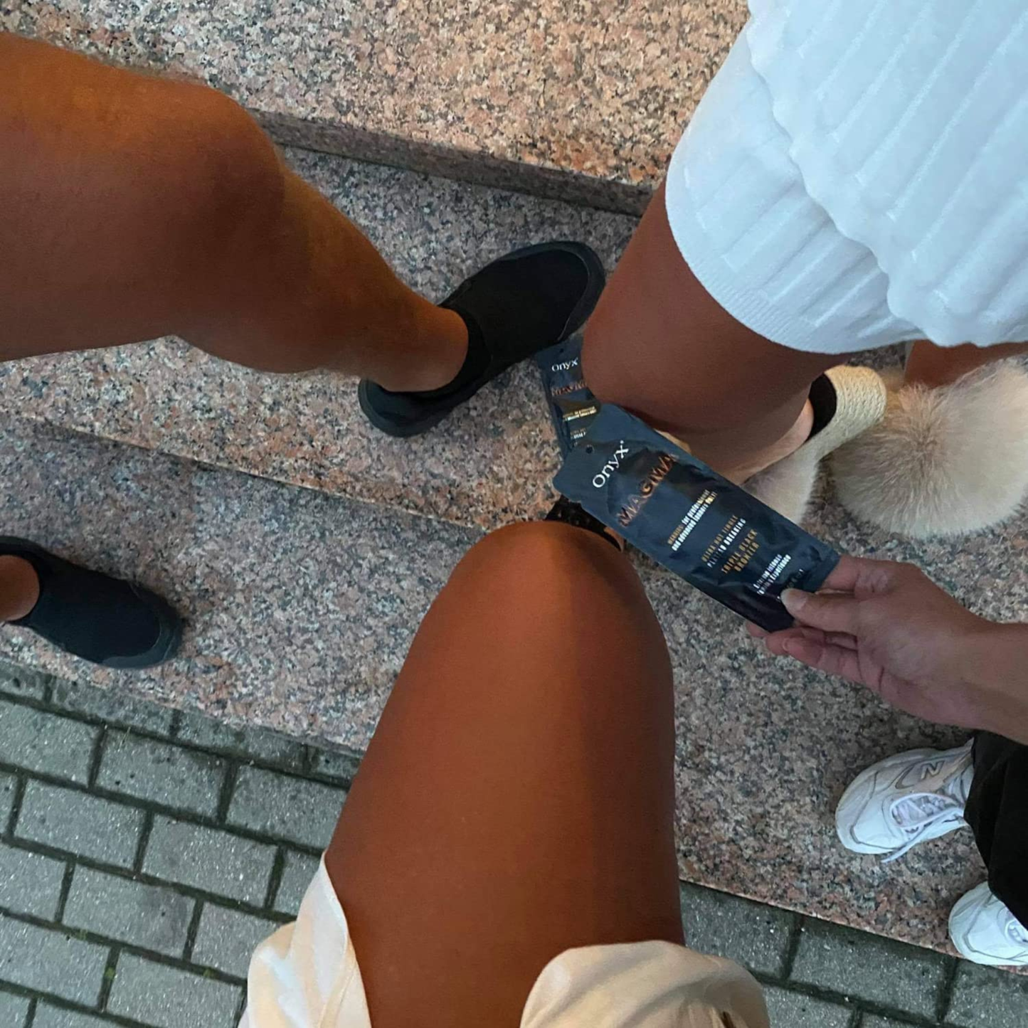 Nogi trzech osób prezentujących efekt po użyciu Onyx Magma. Bronzer z efektem tingle nadaje skórze ciemny, równy kolor.