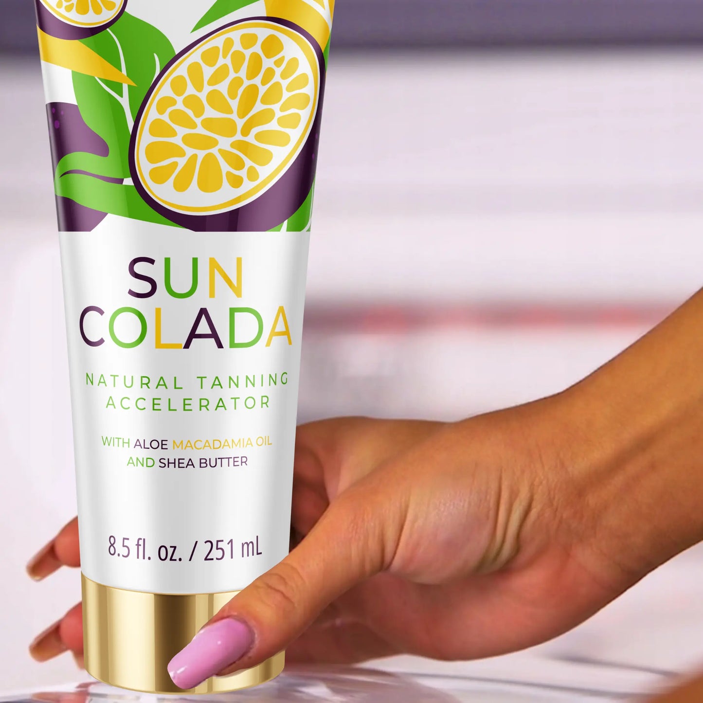 Zbliżenie dłoni trzymającej Onyx Suncolada. Naturalny przyspieszacz do opalania z masłem shea i olejem makadamia.