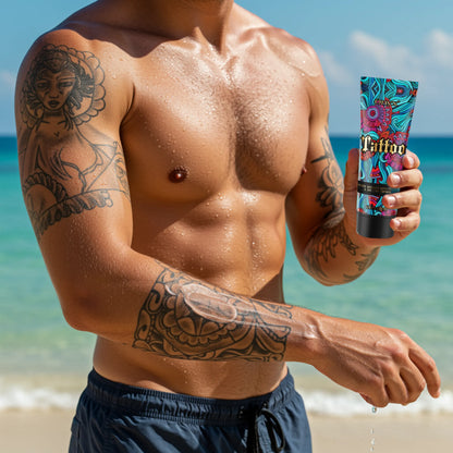 Mężczyzna z tatuażami na ramionach i torsie stoi na plaży, trzymając tubę balsamu Onyx Tattoo Bronzer do pielęgnacji i podkreślania tatuaży podczas opalania